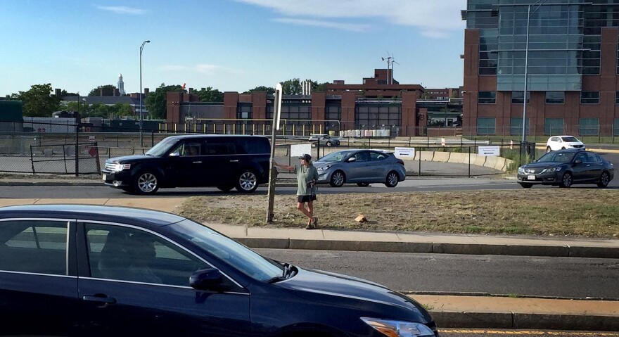 Host Robin Young stands at Boston's Cambridge Street bus stop by the on- and off-ramps for Interstate 90. It was voted the second-worst bus stop in the country, according to Streetsblog USA. (Robin Young/Here & Now)