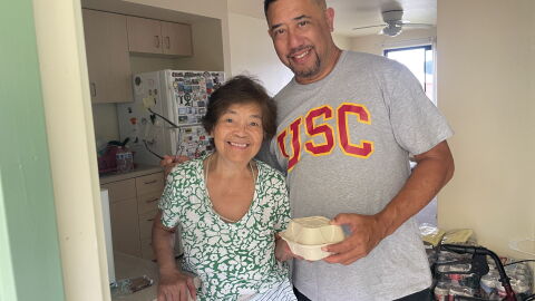 Damian Loo stands with a Kauaʻi resident after delivering a hot meal to her after Hurricane Lowell hit earlier this month.