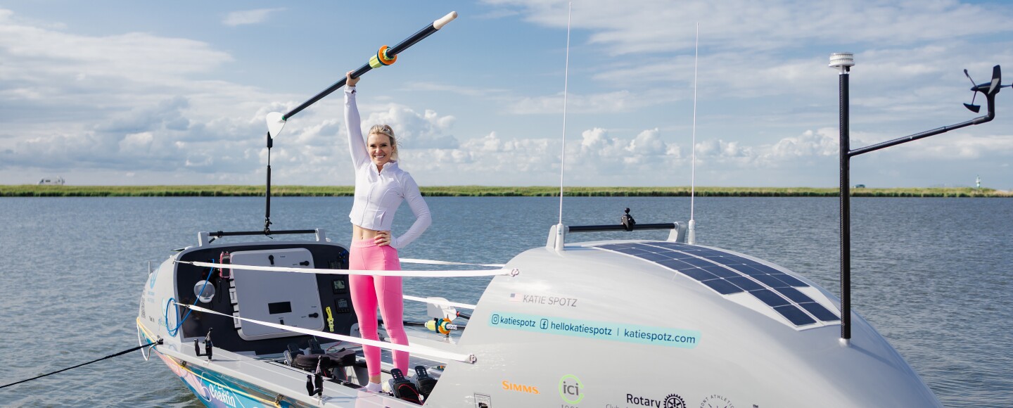 Mentor native Katie Spotz stands aboard her boat with oar raised. Spotz will depart from Peru in December 2026 in an attempt to become the first woman to row solo from South America to Australia and the first American woman to row solo across the whole Pacific Ocean, a 10,000 mile journey to help bring clean water to 100,000 people in Fiji.