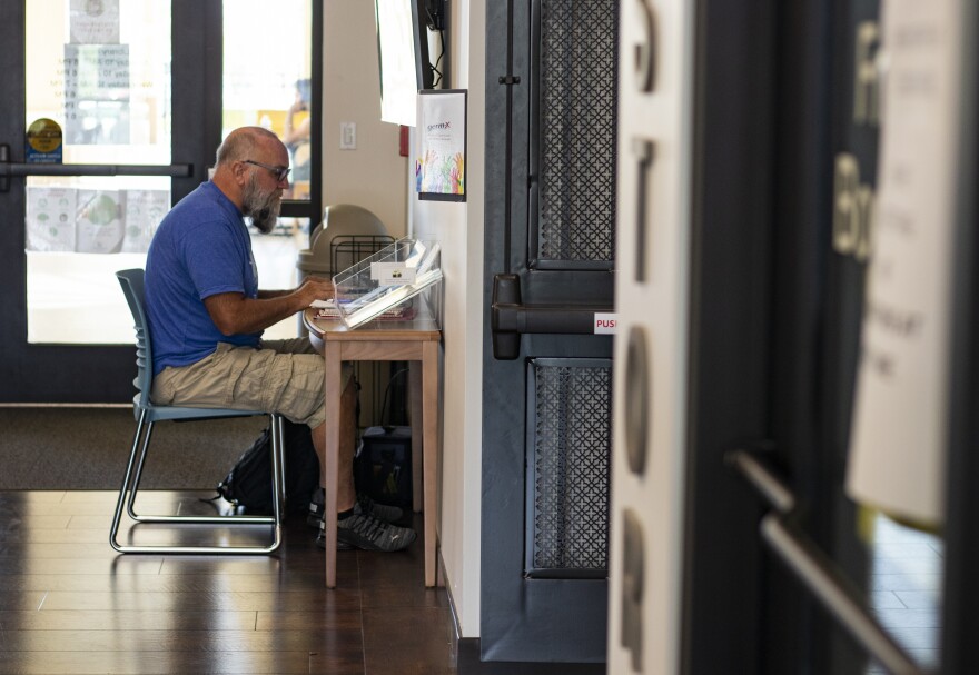 Mark Adkins, 63, Nationwide Financial CPA in compliance and ethics, works at a welcome desk that holds pamphlets at the Punta Gorda Charlotte Library on Tuesday, Oct. 11, 2022.