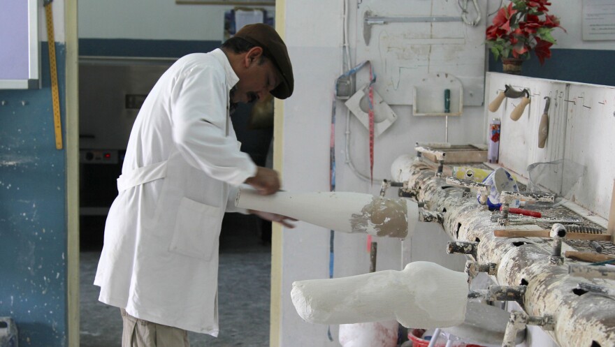 A technician shapes a cast mold for a prosthetic limb at the Red Cross orthopedic clinic in Kabul. The clinic produces about 2,000 prosthetic limbs each year.