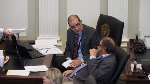 Rep. Tom Gann, R-Inola, left, pulls out a rule book, as Rep. Rick West, R-Heavener, looks on during the House session on May 22, 2025.