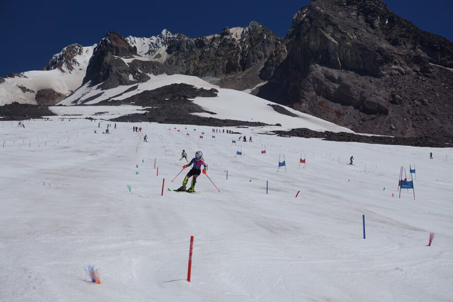 Ski camps practice on the Palmer Snowfield on July 13, 2026, days before Timberline Lodge closed its chairlift due to low snow levels. This had historically been a natural year-round snowfield. Nowadays, the lodge harvests snow from elsewhere on the mountain.