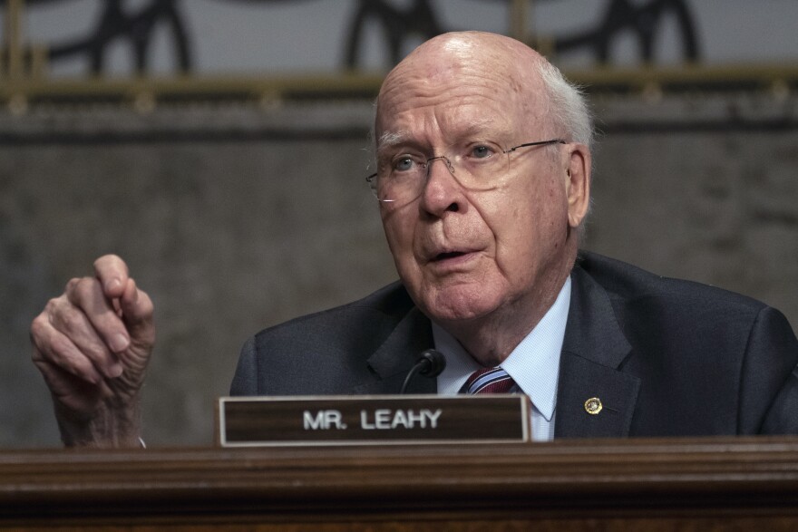 Sen. Patrick Leahy speaking in front of a placard with his name on it