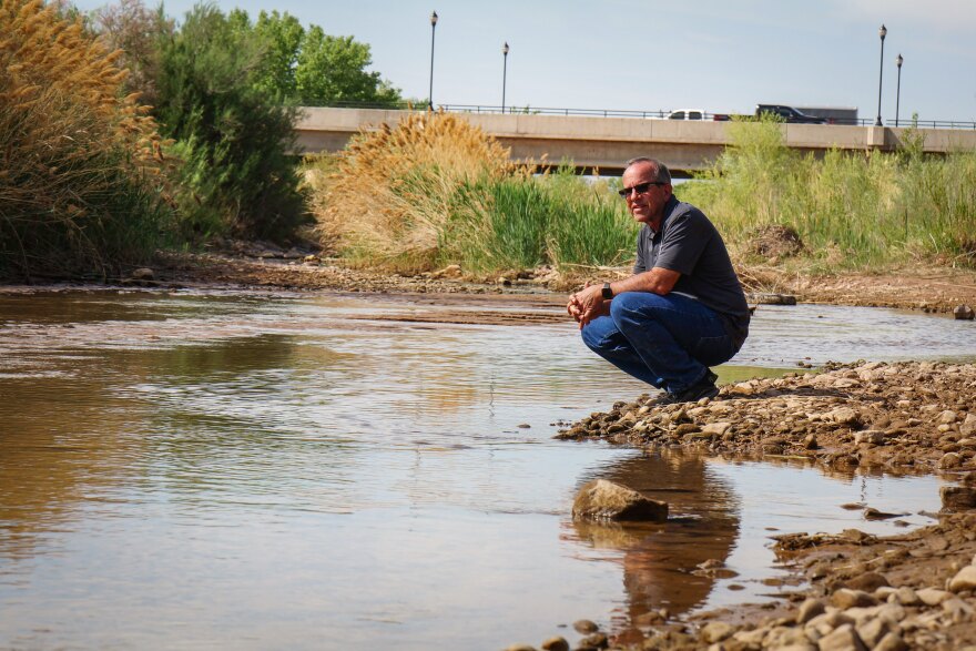 The Washington County Water Conservancy District’s Doug Bennett crouches next to the Virgin River near St. George, April 15, 2025. The relatively small water source is the lifeblood of southwest Utah’s water supply.