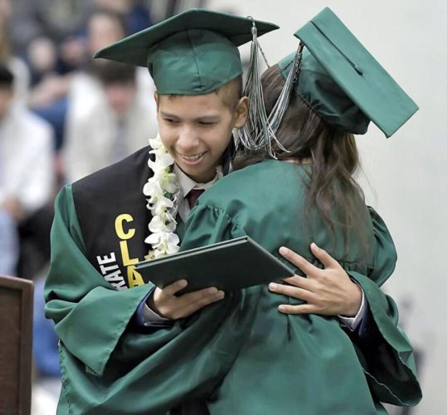 Fernando Lozano hugs Gabby Gonzales after she presented him with his diploma, during a graduation ceremony at Green Canyon High School on Wednesday.