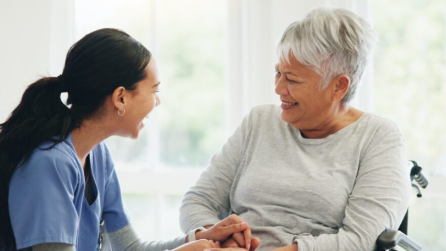 An Freedom Village employee sits with a resident.