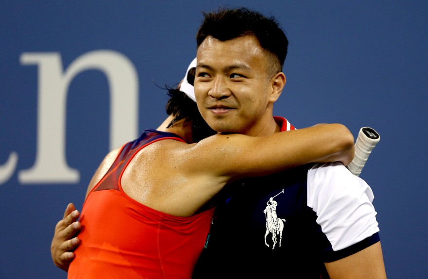 Francesca Schiavone of Italy hugs a ball boy during her first-round women's singles loss to Serena Williams at the 2013 U.S. Open Monday night.