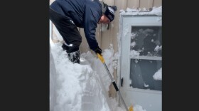 Chelan Gonzalez, a Room at the Inn street outreach team member, digs out a doorway to one of the group's family shelters, in March, 2026.