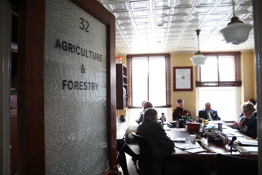 A group of people around a table behind a door that says Agriculture and Forestry