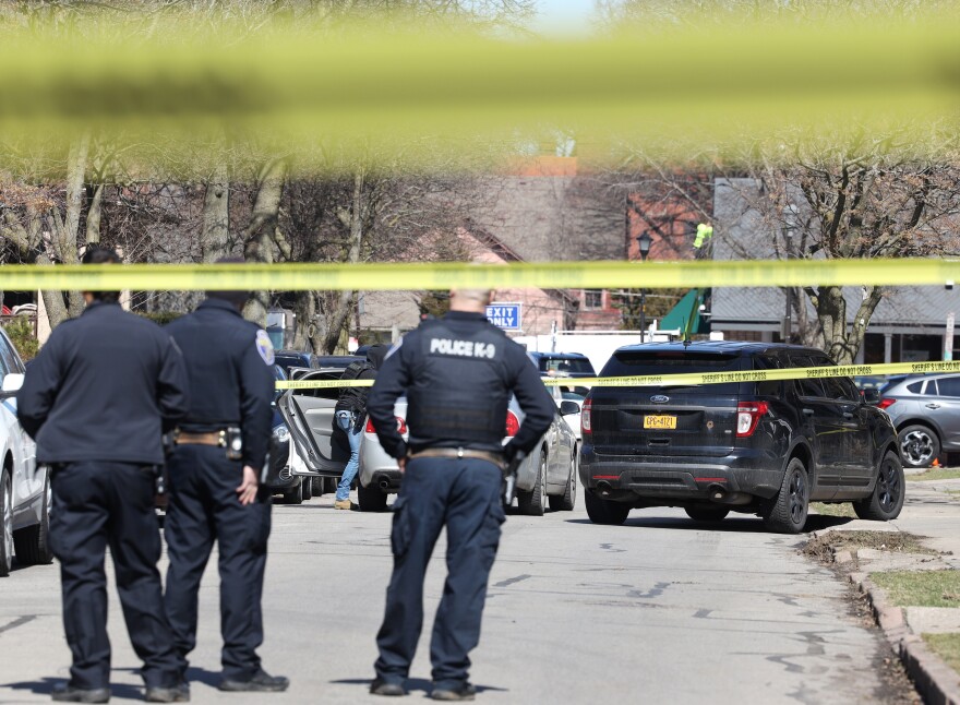 Police officers standing amid yellow caution tape