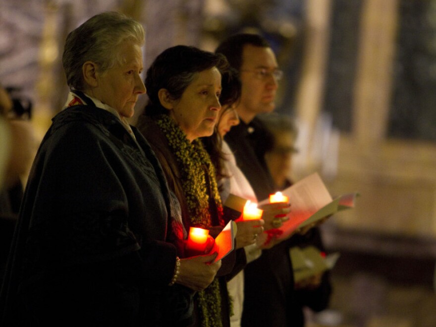 Marie Collins (left), who was assaulted as a 13-year-old by a hospital chaplain in her native Ireland, attends a penitential vigil in Rome 's St. Ignatius Church on Tuesday. She was the only victim to attend the symposium, called "Toward Healing and Renewal."