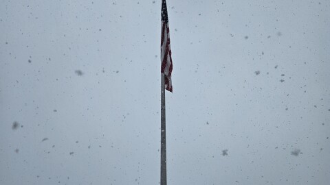An American flag hangs over the parking lot of the Great Barrington, Massachusetts, Stop & Shop in the falling snow on March 3, 2026.