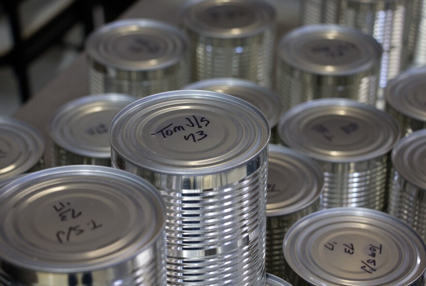 Cans of tomato sauce, after emerging from the pressure cooker.