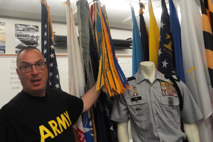 Retired Army Lt. Col. Mo Bolduc shows the display of ribbons and flags that adorn the JROTC room and computer lab at his Florida high school.