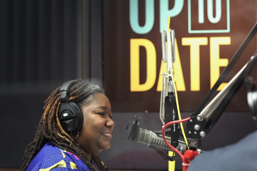 Catina Taylor wearing headphones and seated at a microphone in the KCUR studio.