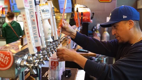 A bartender pours a beer at Topp'd Pizza in Lenexa.