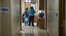 Tama County Public Health Executive Director Shannon Zoffka (right) speaks to a volunteer at the county's COVID-19 vaccination clinic at the former Girls State Training School in Toledo, Iowa.