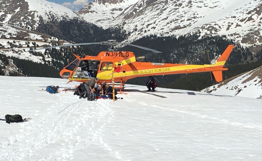 A helicopter crew and rescue volunteers prepare for takeoff.