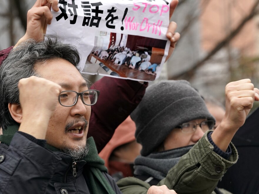 Protesters shout slogans outside the venue of an evacuation drill simulating a North Korea ballistic missile attack on Monday in Tokyo.