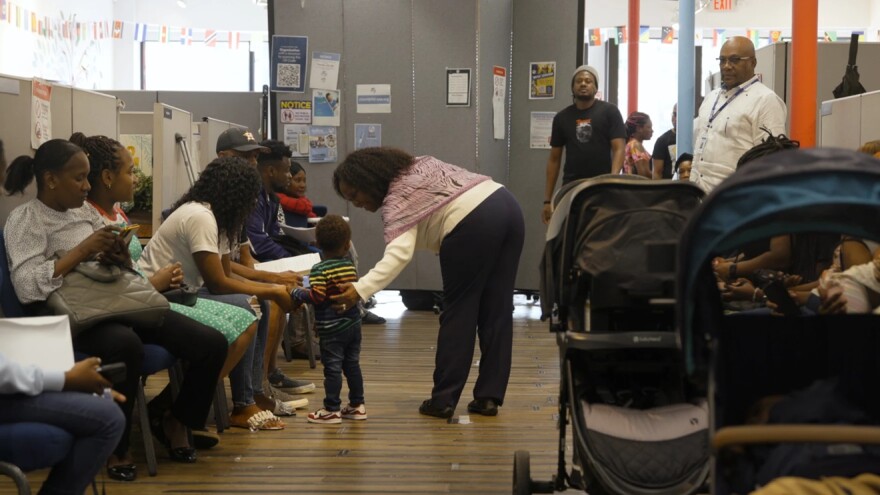 Dr. Geralde Gabeau speaks with a family in the Immigrant Family Services Institute office in the Mattapan neighborhood of Boston on Aug. 5, 2024.