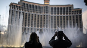 People are silhouetted as they take photos of the fountains at the Bellagio hotel-casino along the Las Vegas Strip, Wednesday, Nov. 11, 2020. 