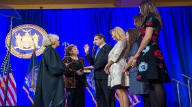 Governor Andrew Cuomo is sworn in to a third term in office by the state's chief judge, Janet DiFiore, as his family looks on