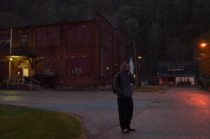 Akal waits at dawn for his aunt to pick him up and take him to work at a factory.