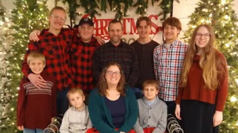 10 members of a family posed in front of a Christmas tree