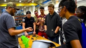 Jeremey Rorie shows Penn High School students what he does for work at B&B Molders in Mishawaka.
