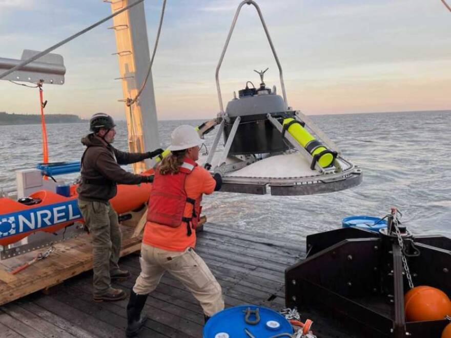 Researchers steady a bottom lander, deployed in a tidal study at the East Foreland this summer.