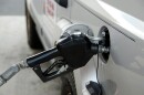 A nozzle filling up a vehicle with gas