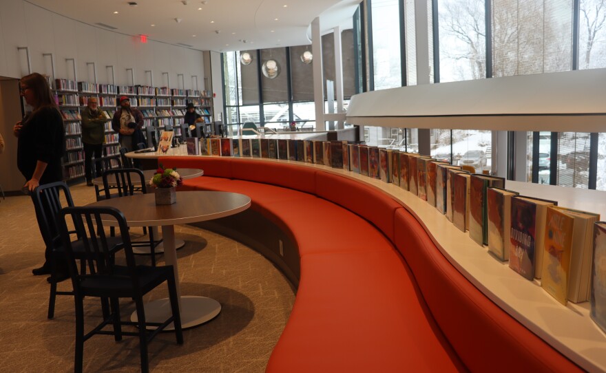 The line of books standing on a ledge on the upper level of the Portland Library