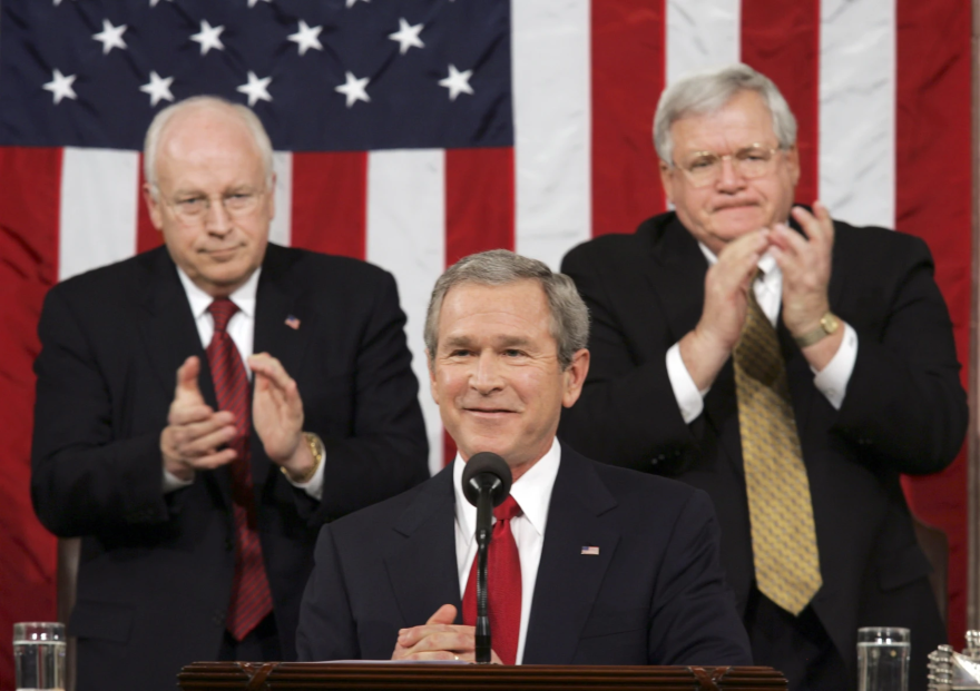 Then-President George W. Bush pauses as he is welcomed to the House Chamber to deliver his annual State of the Union speech before a joint session of Congress, at the U.S. Capitol in Washington Feb. 2, 2005. He is applauded at rear by Vice President Dick Cheney, left, and Speaker of the House of Representatives Dennis Hastert, R-Ill.