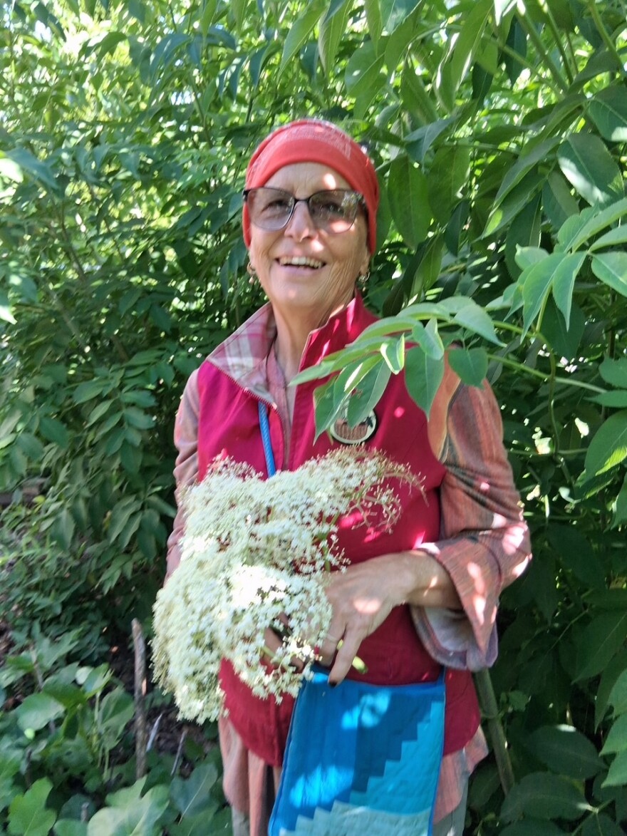 A woman in pink holds a cluster of white flowers.