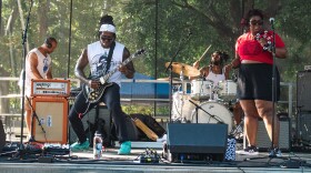 A band performs to a crowd on a stage.