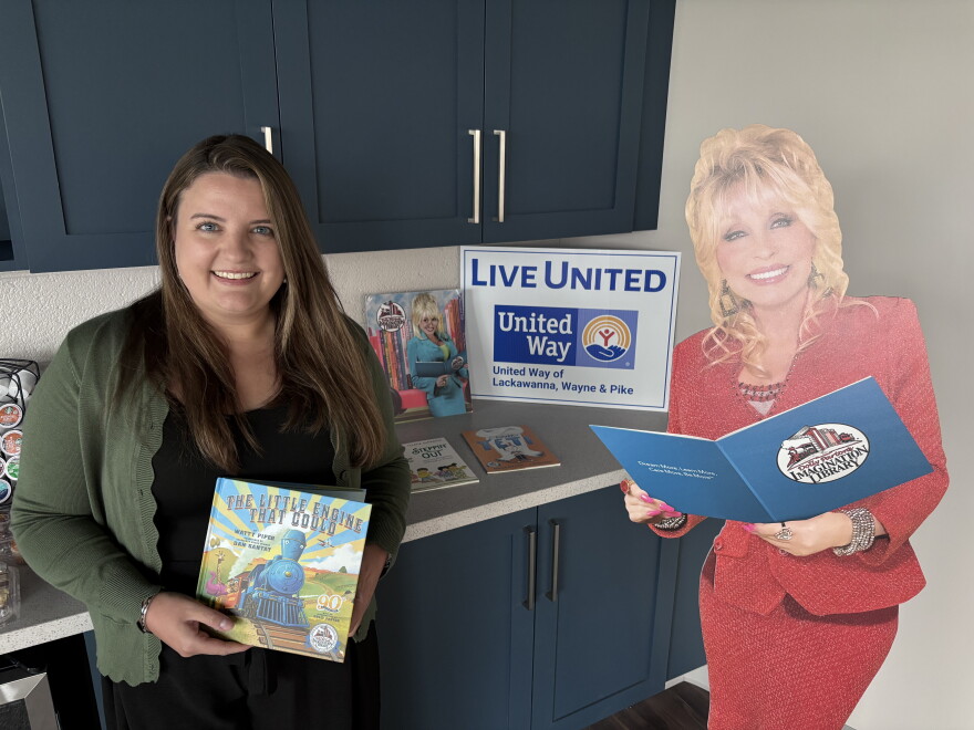 Angela Bassani, President & CEO of United Way of Lackawanna, Wayne & Pike, holds one of the first books children receive from Dolly Parton's Imagination Library. The United Way runs the local chapter of the library program.