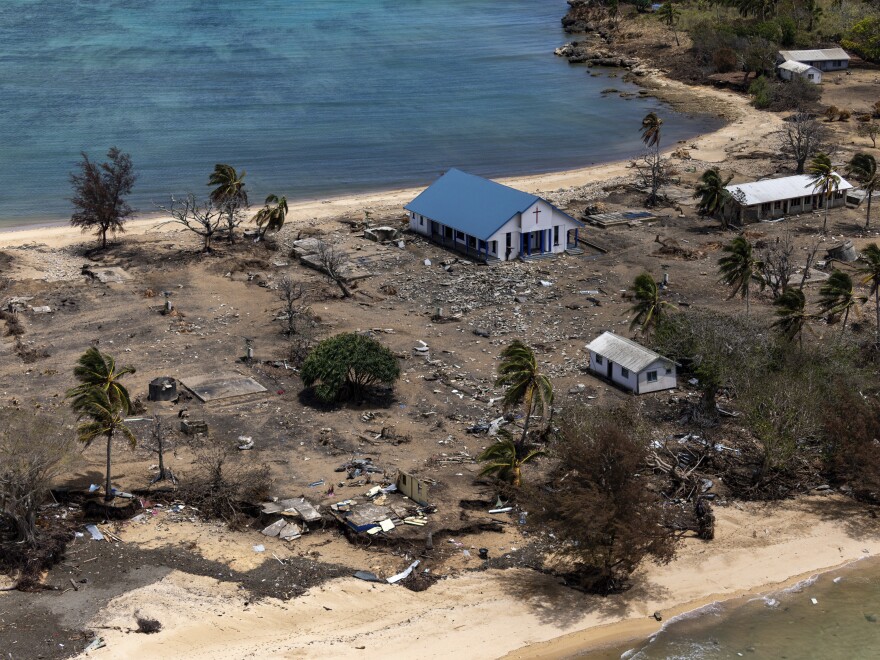 FILE - In this photo provided by the Australian Defence Force, debris from damaged building and trees are strewn around on Atata Island in Tonga, on Jan. 28, 2022, following the eruption of an underwater volcano and subsequent tsunami. Tonga's main internet connection to the rest of the world has finally been restored more than five weeks after the huge volcanic eruption and tsunami severed a crucial undersea cable. The fiber-optic cable is now fully operational again after being reconnected Tuesday, Feb. 22, said Samiuela Fonua, the chairperson at Tonga Cable Ltd., the state-owned company that owns the cable. (POIS Christopher Szumlanski/Australian Defence Force via AP, File)