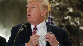 President Trump reaches into his suit jacket to read a quote he made on Saturday regarding the events in Charlottesville, Va., as he speaks to the media in the lobby of Trump Tower in New York, Tuesday, Aug. 15, 2017. (Pablo Martinez Monsivais/AP)