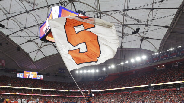 A Syracuse cheerleader waves a flag after a touchdown during the first half of an NCAA college football game against North Carolina State on Saturday, Oct. 15, 2022, in Syracuse, N.Y. (AP Photo/Joshua Bessex)