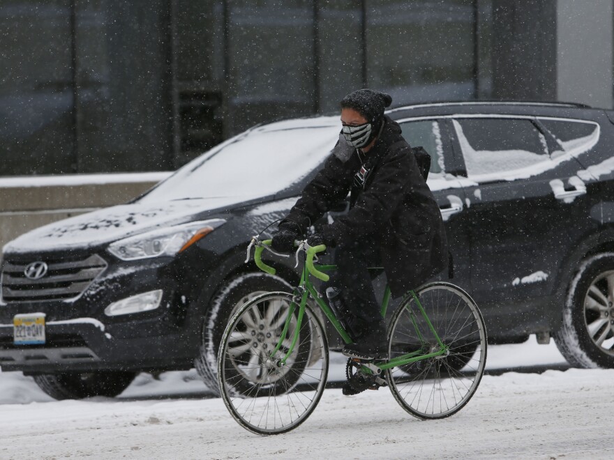 Traffic slowed in downtown Denver on Wednesday as snow fell on the city.