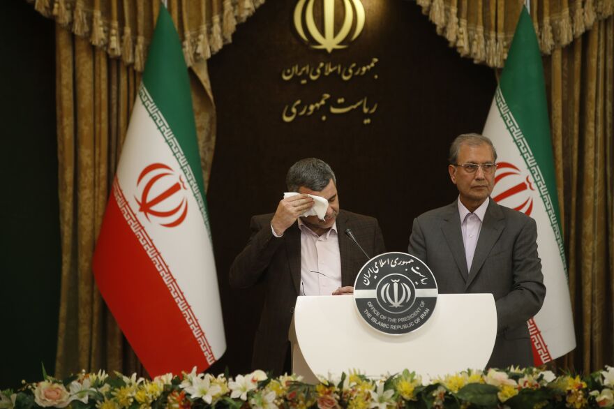 Iranian Deputy Health Minister Iraj Harirchi (left) wipes the sweat off his face, during a news conference with government spokesman Ali Rabiei in Tehran on Feb. 23. The next day, Harirchi confirmed he tested positive for the novel coronavirus.