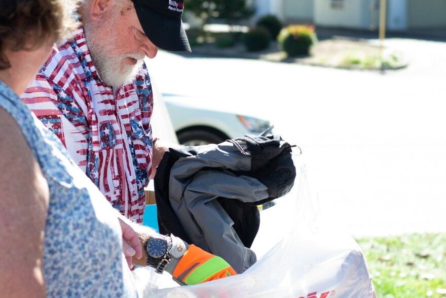 Daniel Almarode sorts a bag of winter coats donated to hurricane survivors.