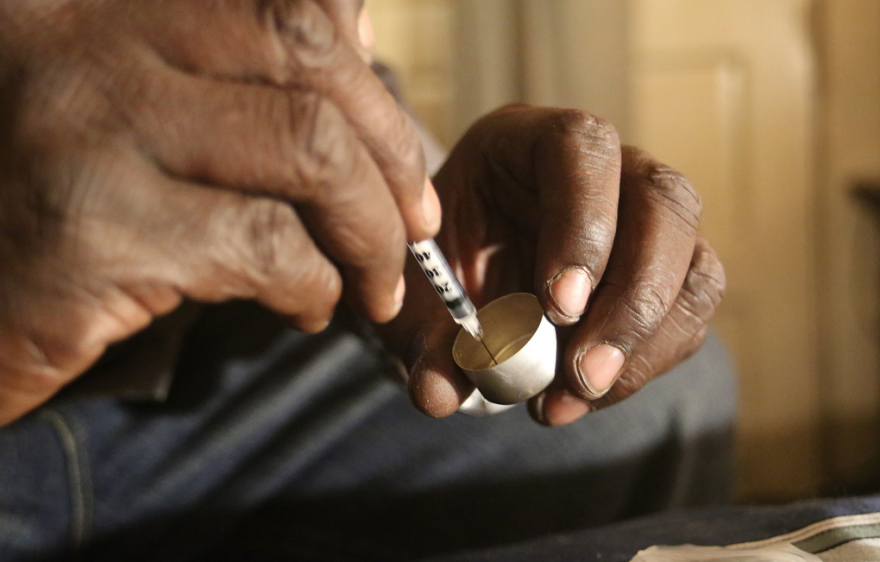A man draws heroin into a syringe. Democrats in Congress are working to halt opioid legislation in an attempt to make the laws better.