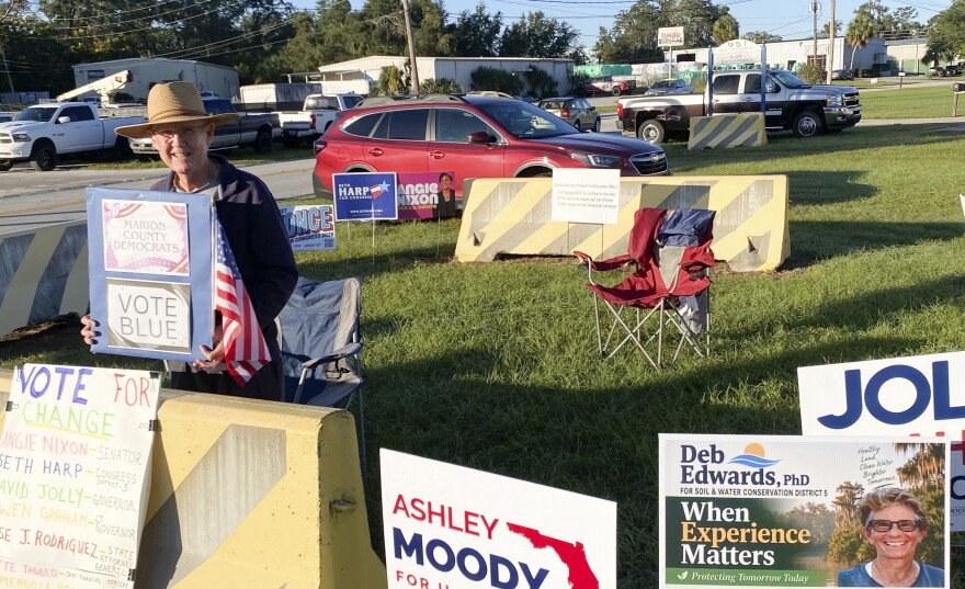 Retired high school math teacher Tom Lakin stands inside a special enclosure for campaign signs and campaigners at the Marion County Supervisor of Elections Office in Ocala on Thursday, the first day of early voting for the Nov. 3 General Election.