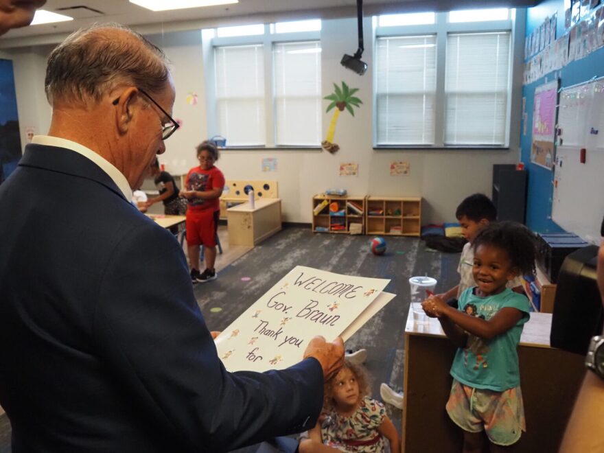 Indiana Gov. Mike Braun admires a welcome message, delivered to him by a child, at Shepherd Community Center’s Minnie Hartmann Neighborhood Childcare facility on Tuesday, July 21, 2026.