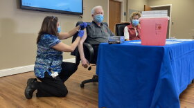 Stacy Wilson of the Wilson County Health Department injects former Gov. Jim Hunt with his first dose of the COVID-19 vaccine