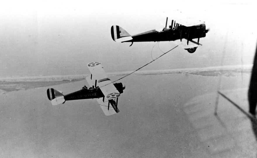 Two DH-4 biplanes prove the theory of air-to-air refueling.