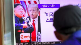A man watches a television news program showing President Trump and North Korean leader Kim Jong Un at a railway station in Seoul on Aug. 9, 2017. (Jung Yeon-Je/AFP/Getty Images)