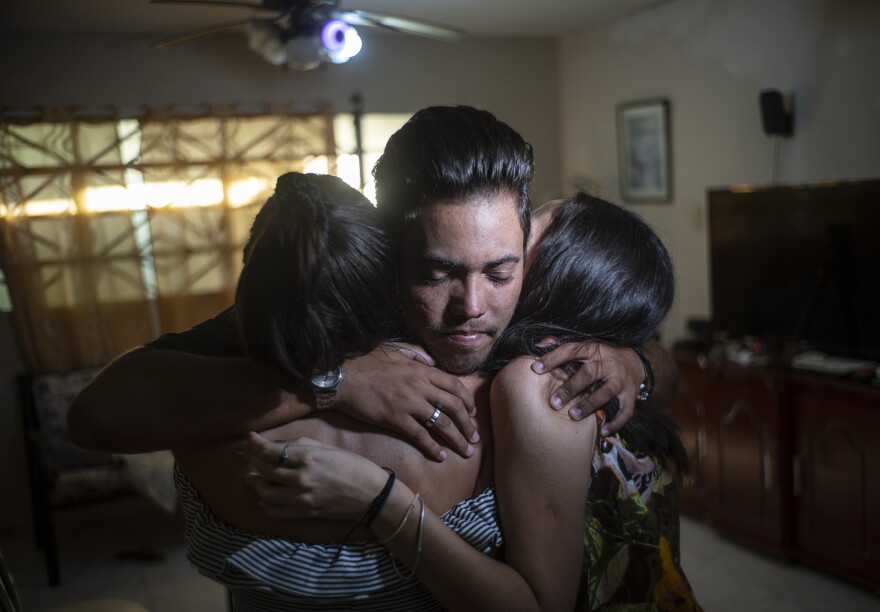 Marcos Marzo hugs two of his friends who came to say goodbye upon receiving the news that he had obtained a permit to travel to the United States,  in Havana, Cuba, Wednesday, Jan 25, 2023. Now in the U.S., his dream is to do a master’s degree at the Massachusetts Institute of Technology and work as an engineer, which he says is his passion. (AP Photo/Ramon Espinosa)